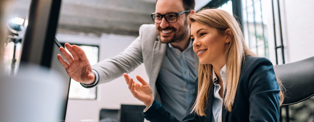 Working together on project. Two young business colleagues working on computer